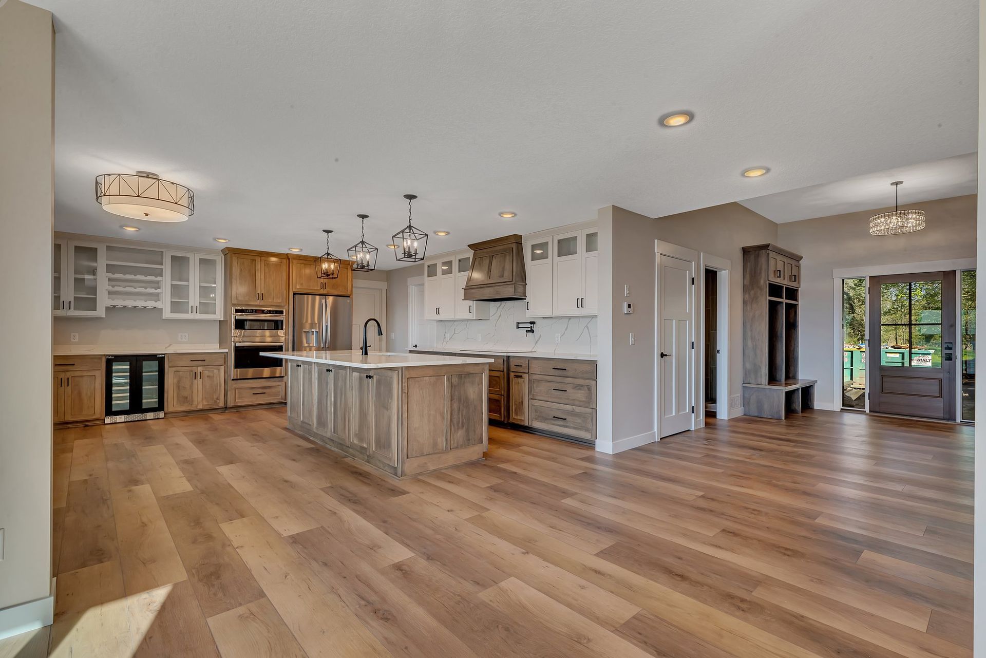 A kitchen with hardwood floors and a large island in the middle of the room.