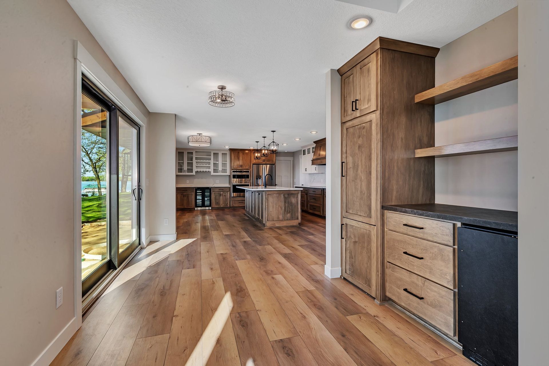 A large empty kitchen with hardwood floors and sliding glass doors.