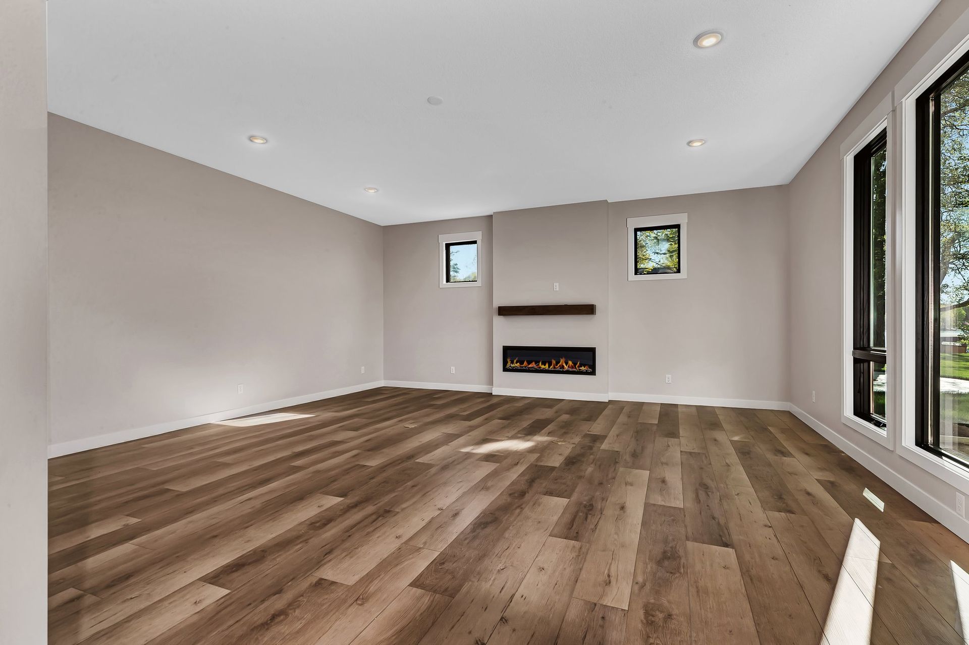 An empty living room with hardwood floors and a fireplace.
