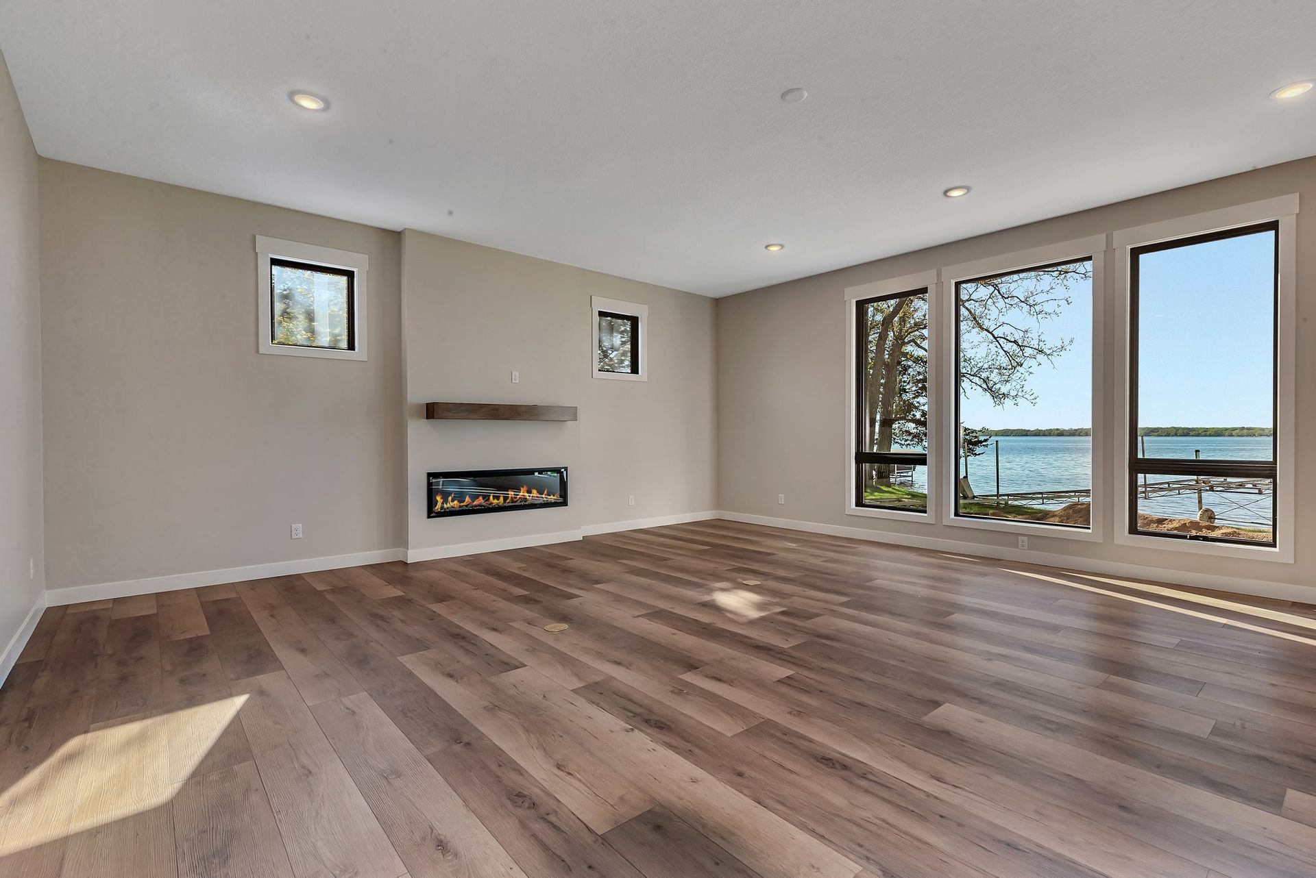 An empty living room with hardwood floors and a fireplace.