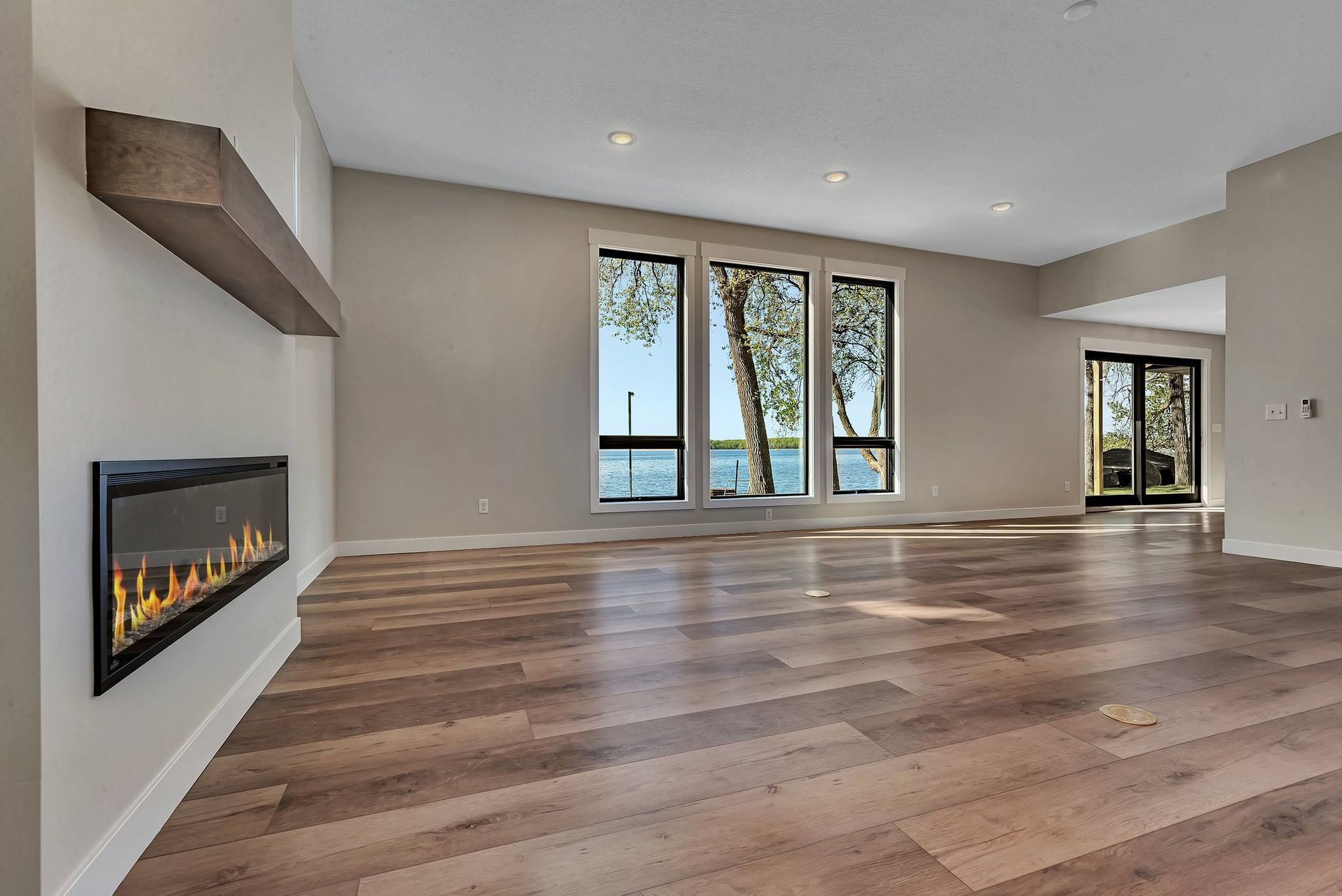 An empty living room with hardwood floors and a fireplace.