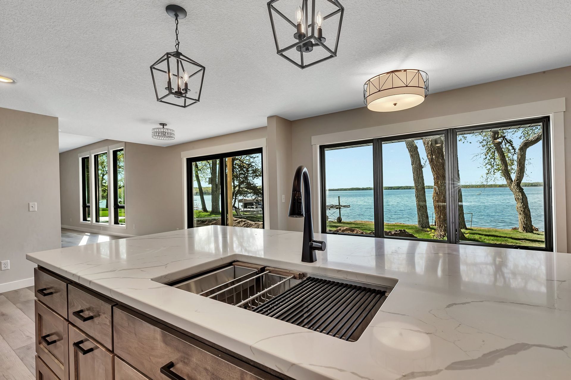 A kitchen with a sink and a view of a lake.