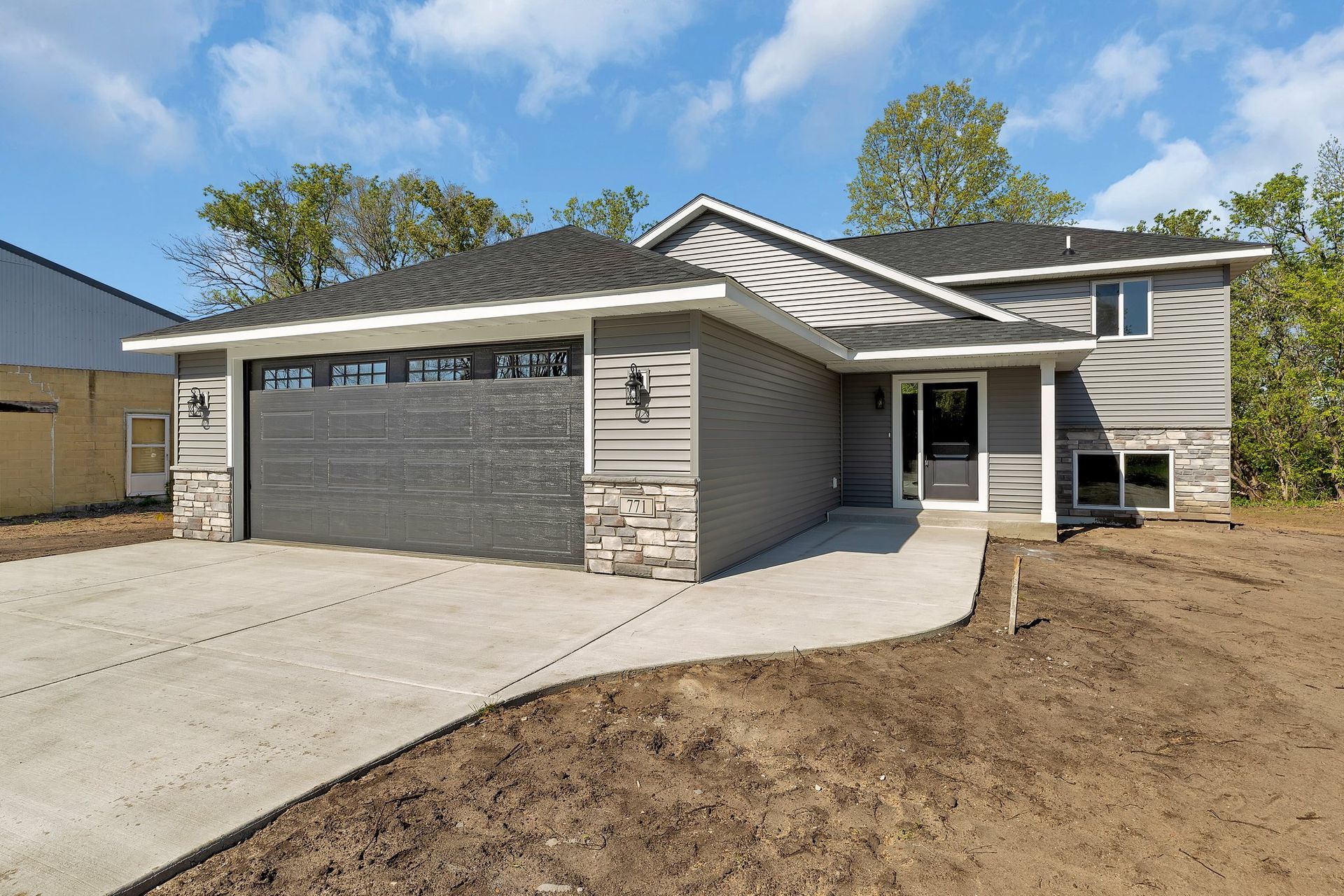 A newly built house with a large garage and a concrete driveway.