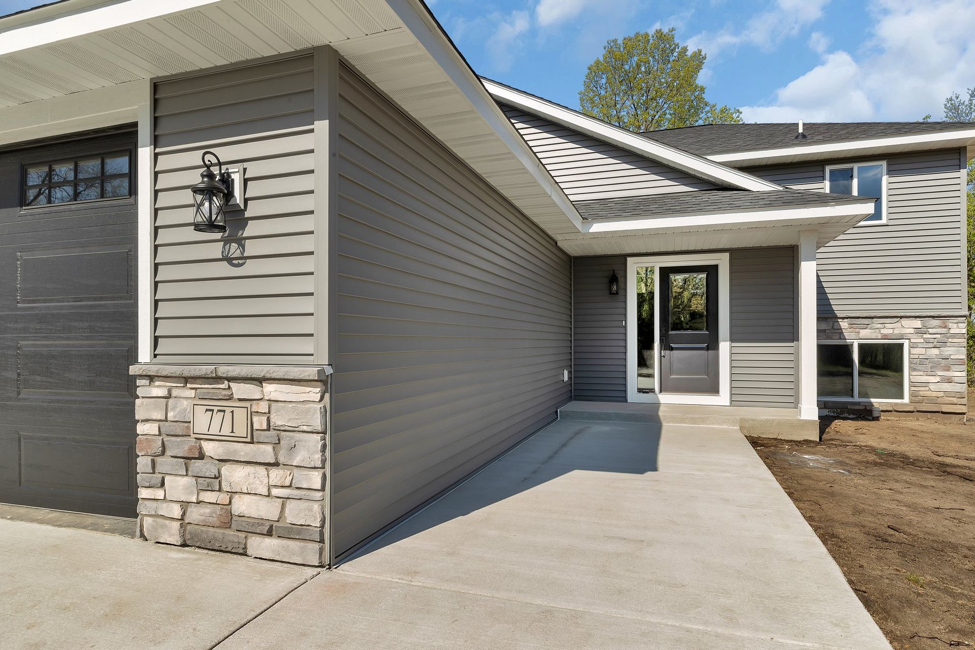 A house with a concrete walkway leading to the front door.