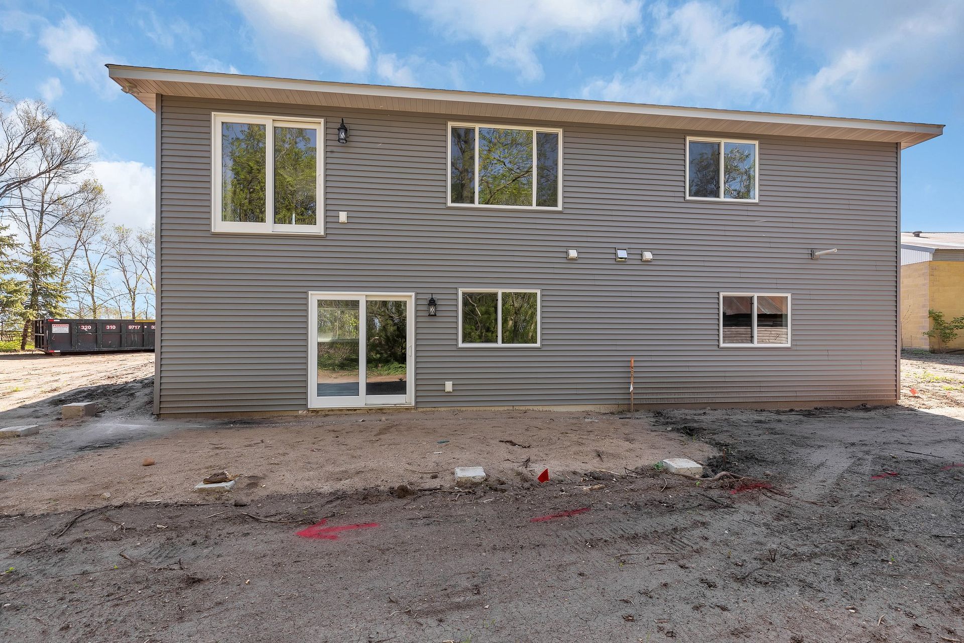 The back of a house with a lot of windows and doors.