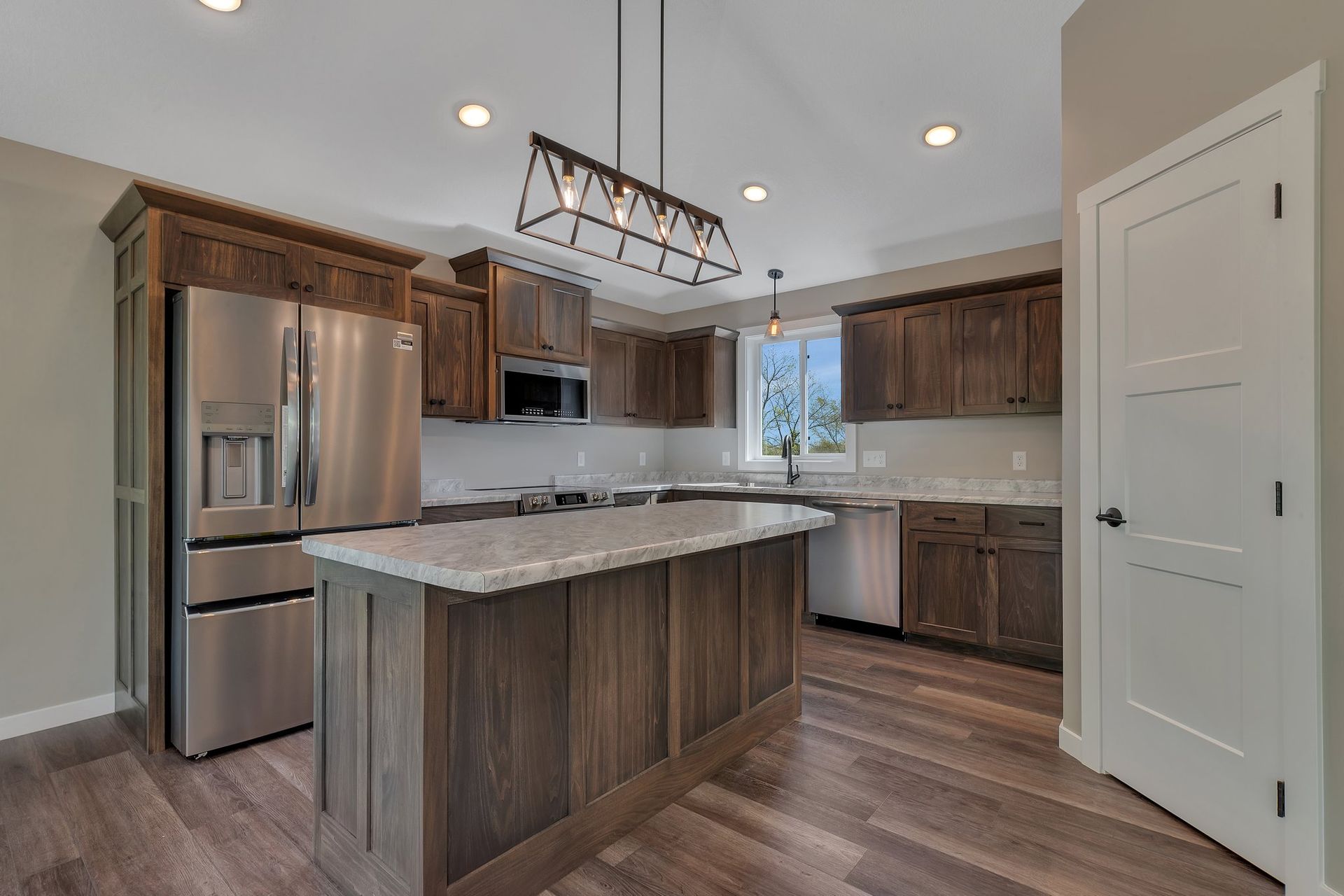 A kitchen with stainless steel appliances , wooden cabinets , and a large island.