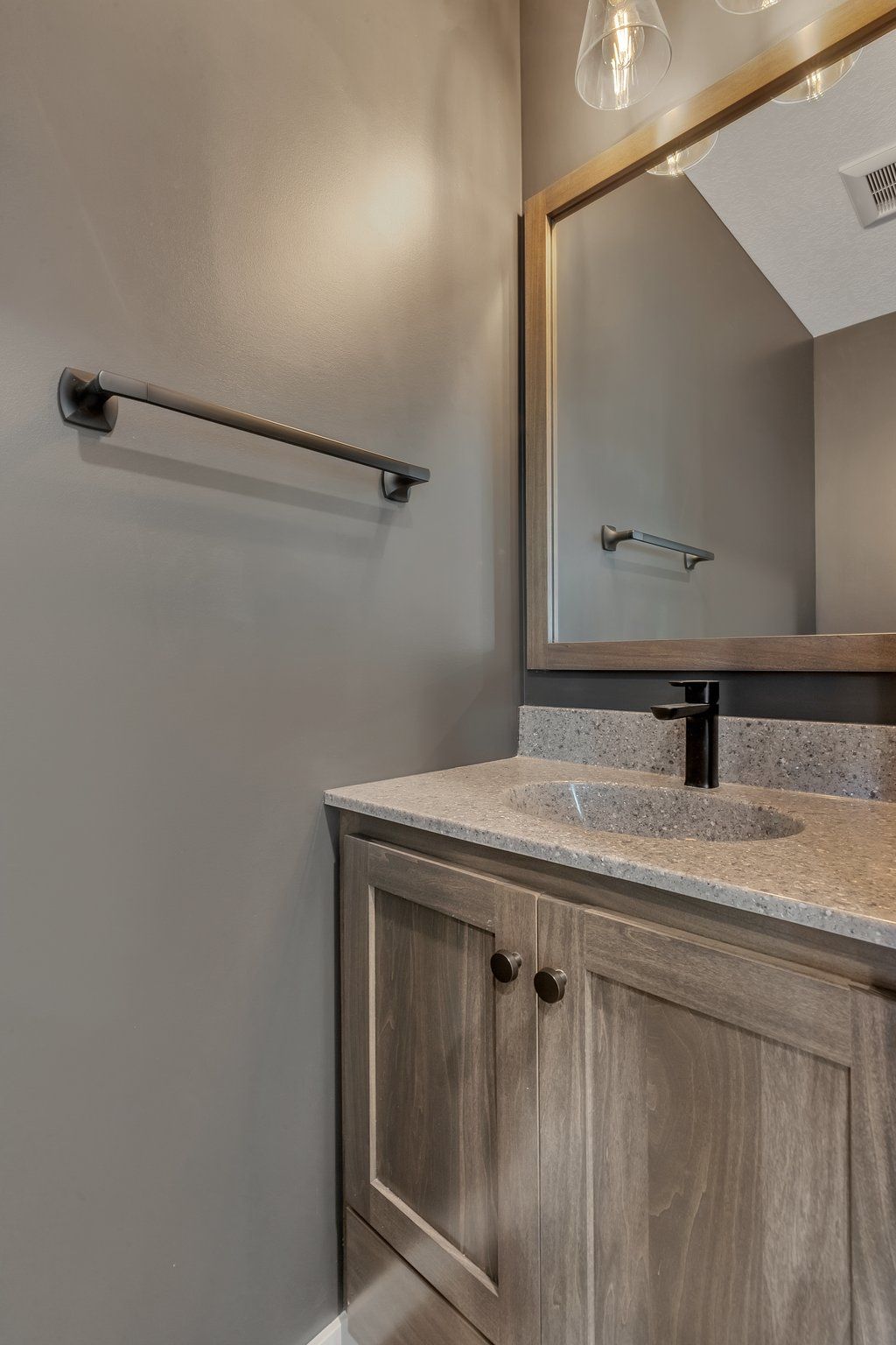 A bathroom with a sink , mirror and towel rack.