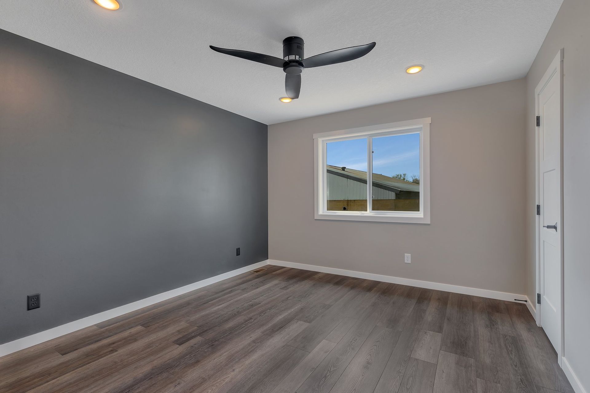 An empty room with a ceiling fan and a window