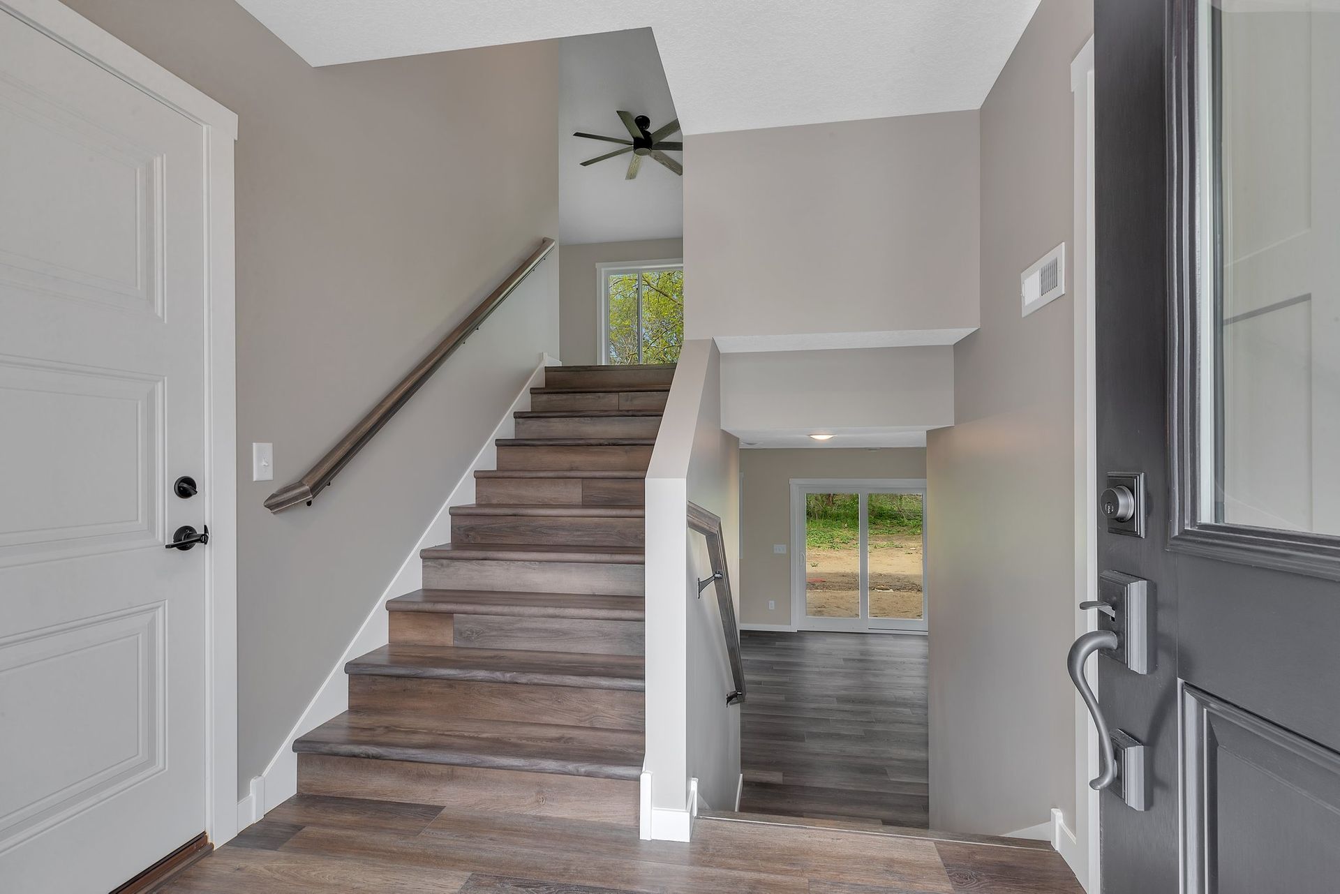 A hallway with stairs leading up to the second floor of a house.