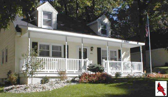 A white house with a porch and a flag