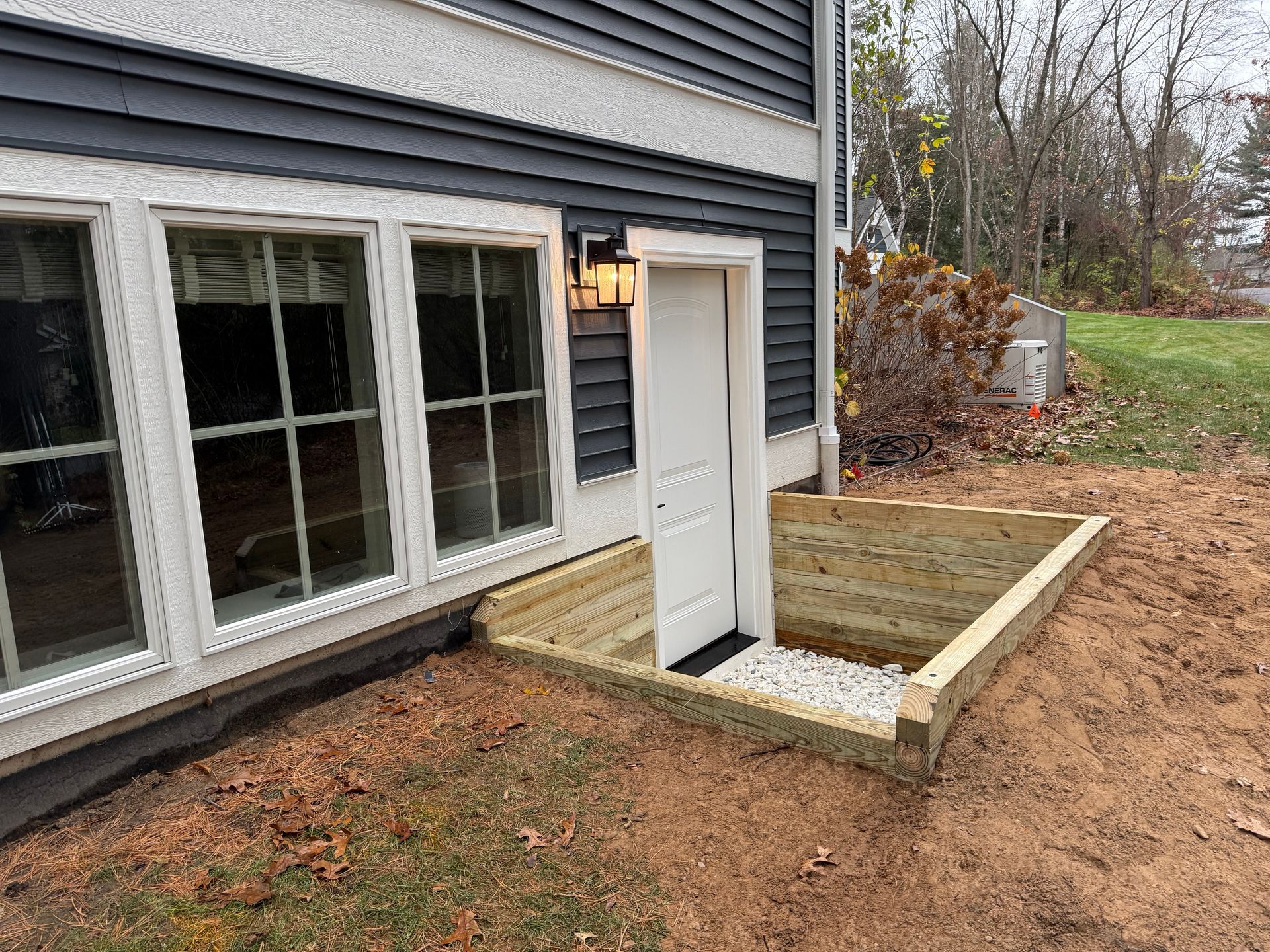 House exterior with a small new wooden porch and steps beside a white door and windows
