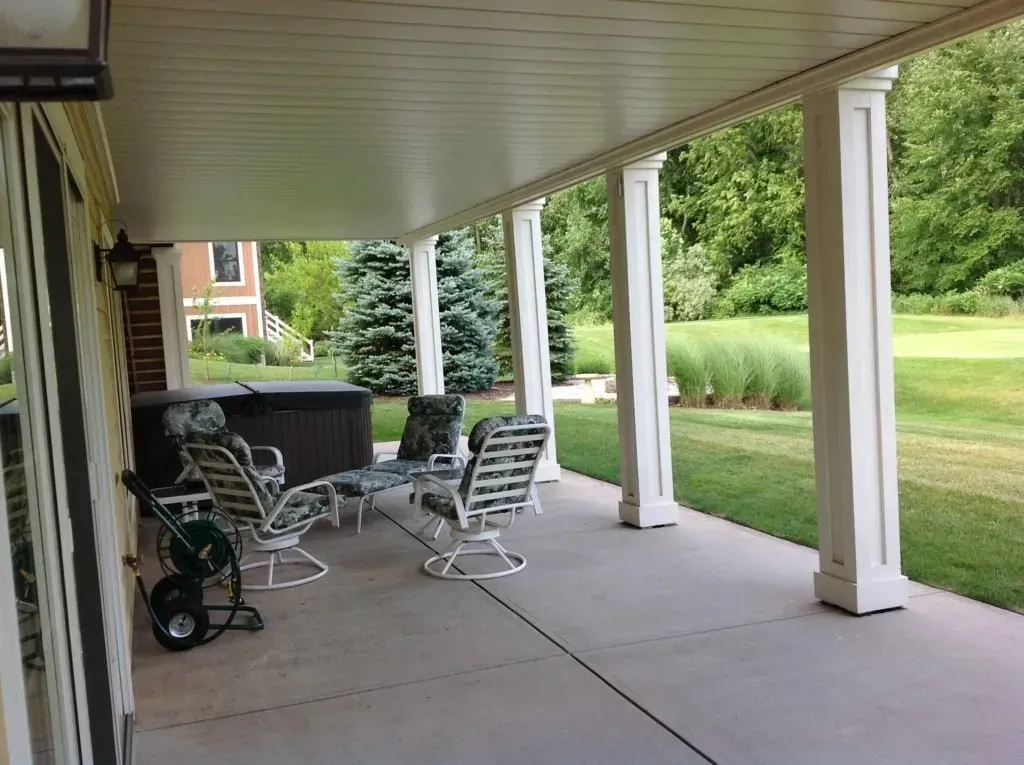 A porch with chairs and a hot tub in the background