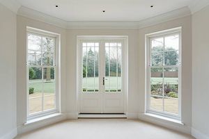 An empty room with a lot of windows and a door