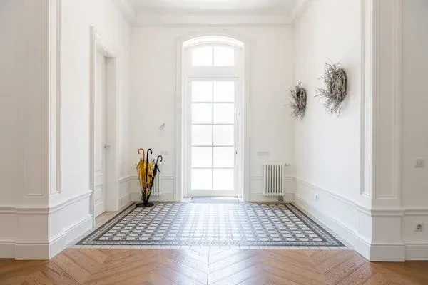 An empty hallway with a wooden floor and a large window.