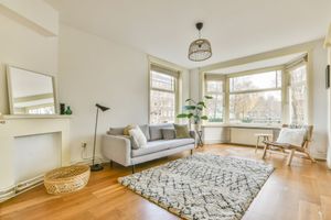 A living room with a couch , chair , rug and fireplace.