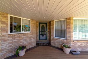 A brick house with a porch and a green door.