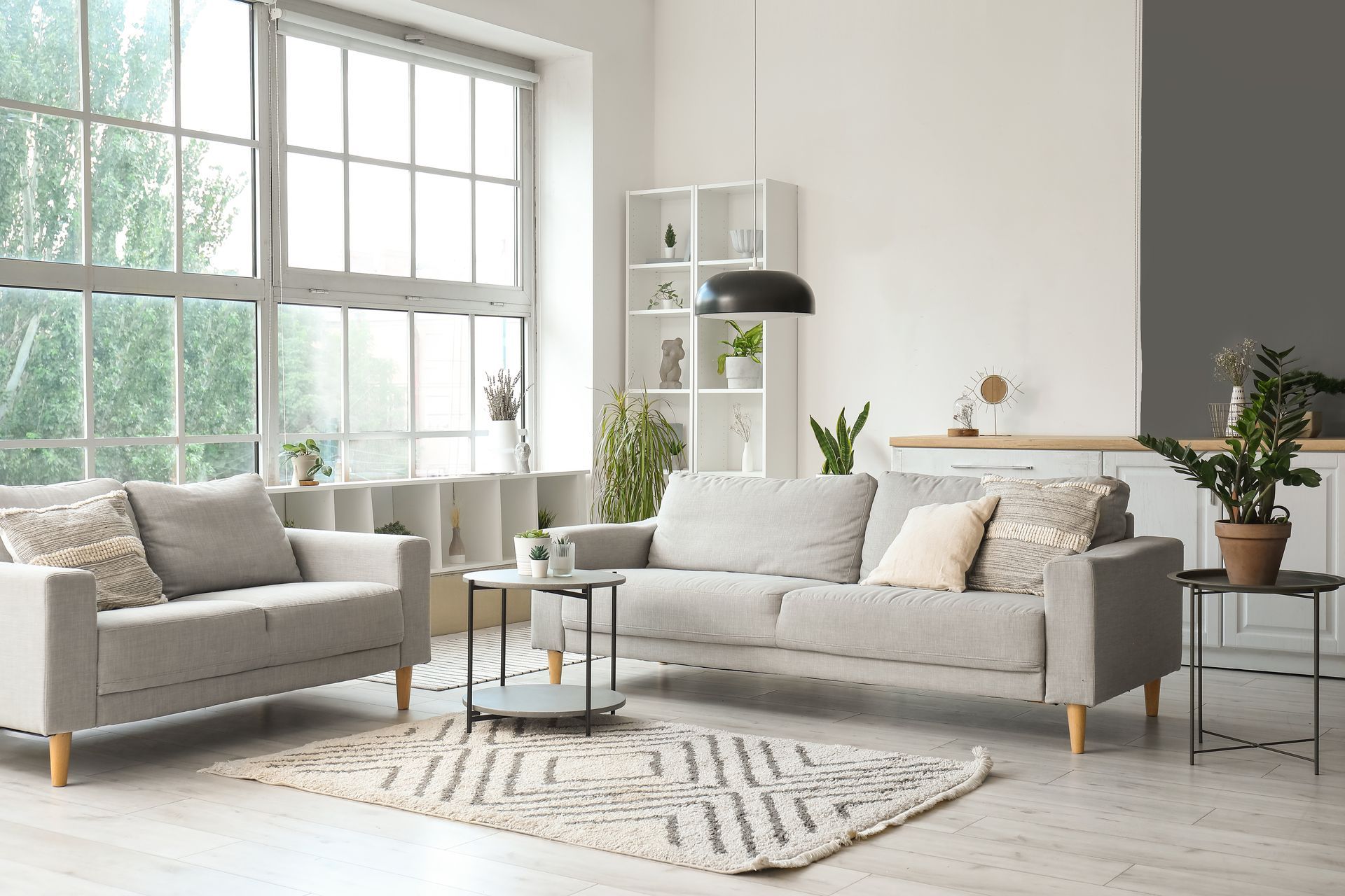 A living room with two couches , a rug , and a large window.