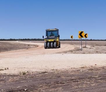 A Yellow Truck is Driving Down a Dirt Road — Lohman Contracting in Emerald, QLD