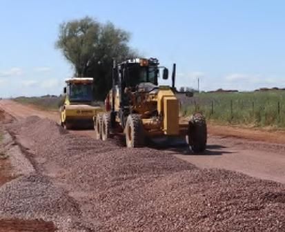 A Couple of Tractors Are Driving Down a Dirt Road — Lohman Contracting in Emerald, QLD