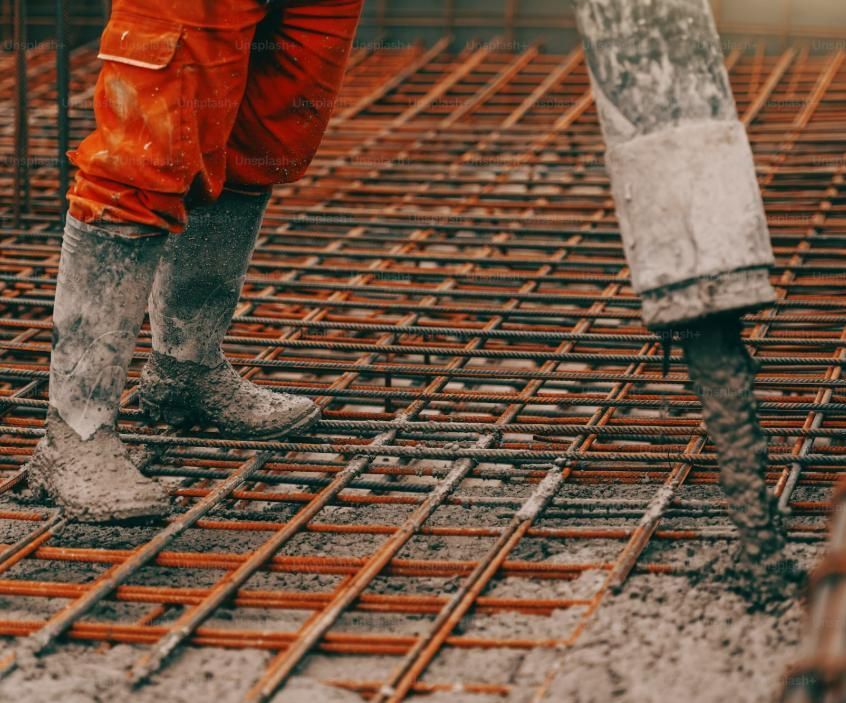 A Construction Worker is Pouring Concrete on a Steel Mesh Floor — Lohman Contracting in Emerald, QLD
