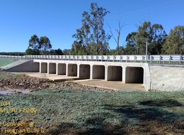 A Bridge is Being Built Over a River With Trees in the Background — Lohman Contracting in Emerald, QLD