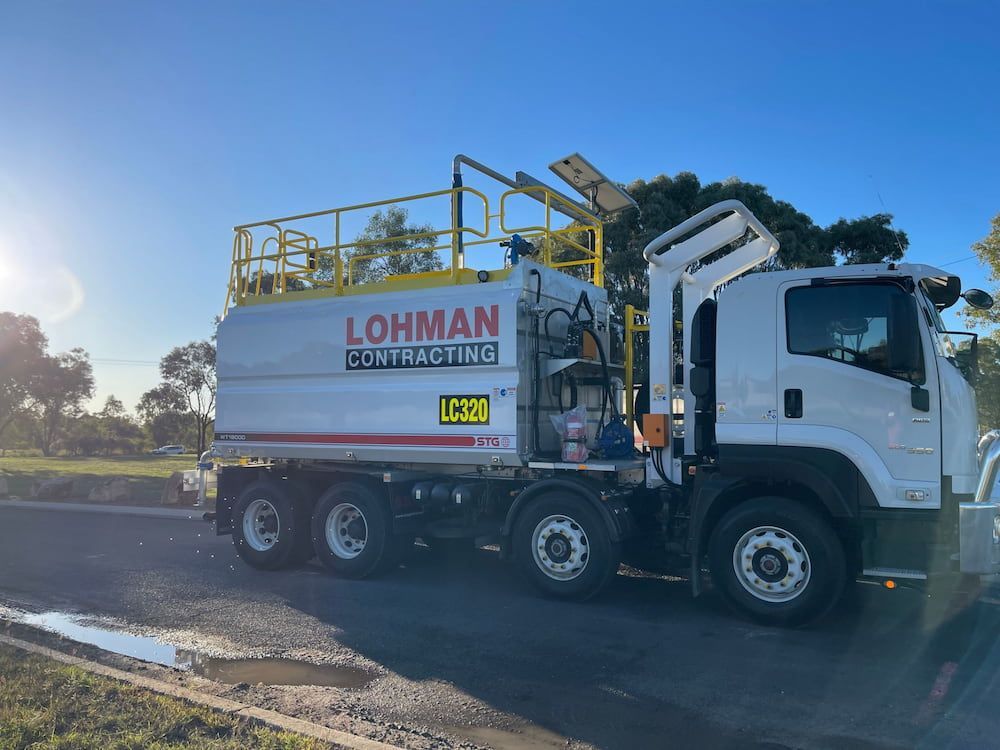 A White Truck With A Yellow Ladder On Top Of It Is Parked — Lohman Contracting in Mareeba, QLD