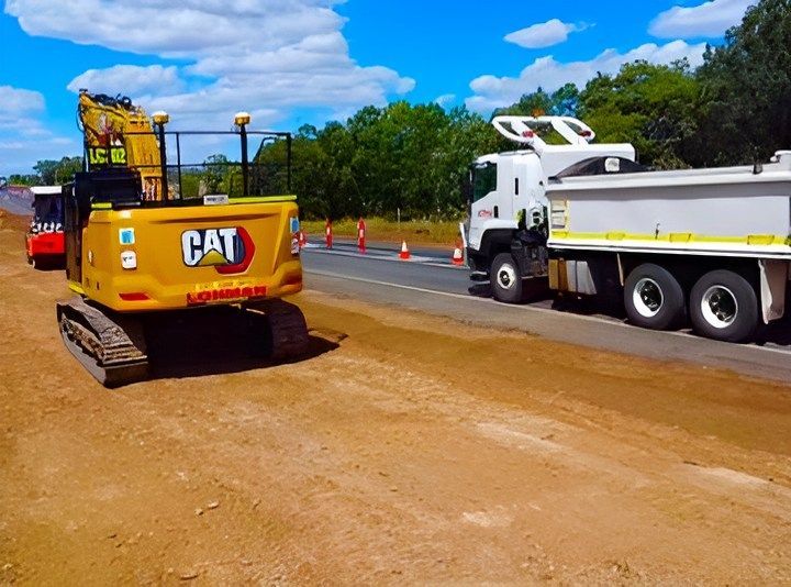 A Person Is Installing Drain Pipes In A Trench — Lohman Contracting in Emerald, QLD
