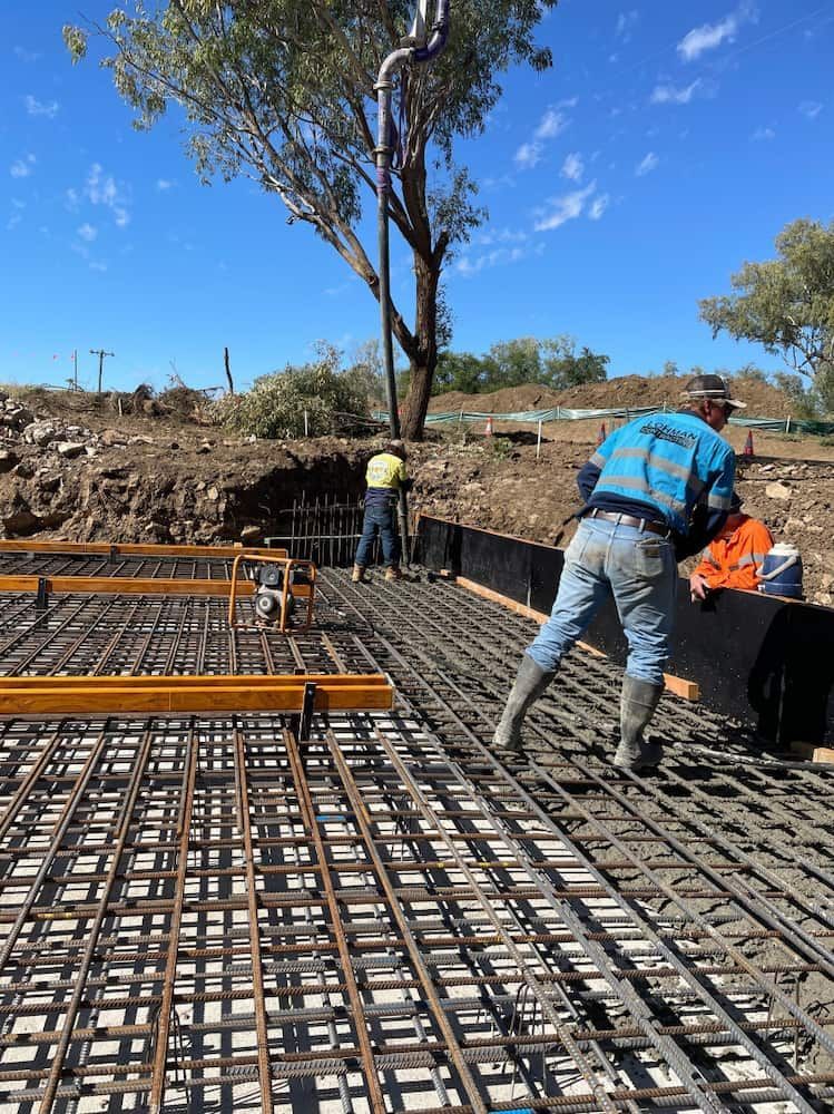 A Group Of Construction Workers Are Working On A Concrete Floor — Lohman Contracting in Mareeba, QLD