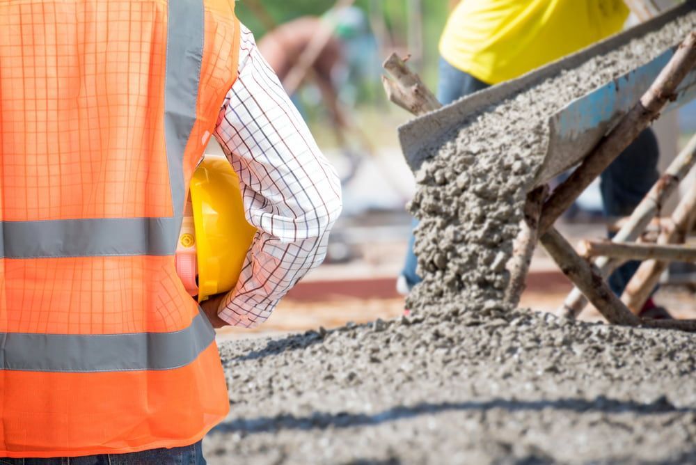 A Construction Worker Wearing A Hard Hat Is Standing — Lohman Contracting in Biloela, QLD
