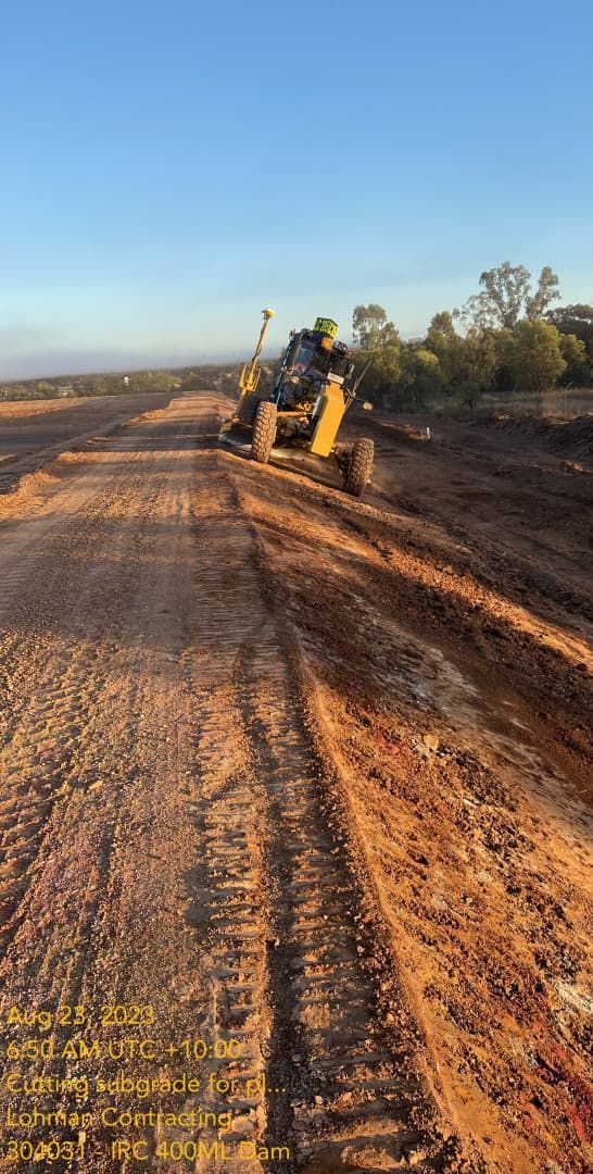 A Bulldozer Is Driving Down A Dirt Road — Lohman Contracting in Emerald, QLD