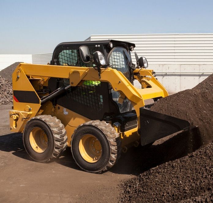 A Small Yellow Bob Cat Collecting A Pile Of Soil — Lohman Contracting in Emerald, QLD