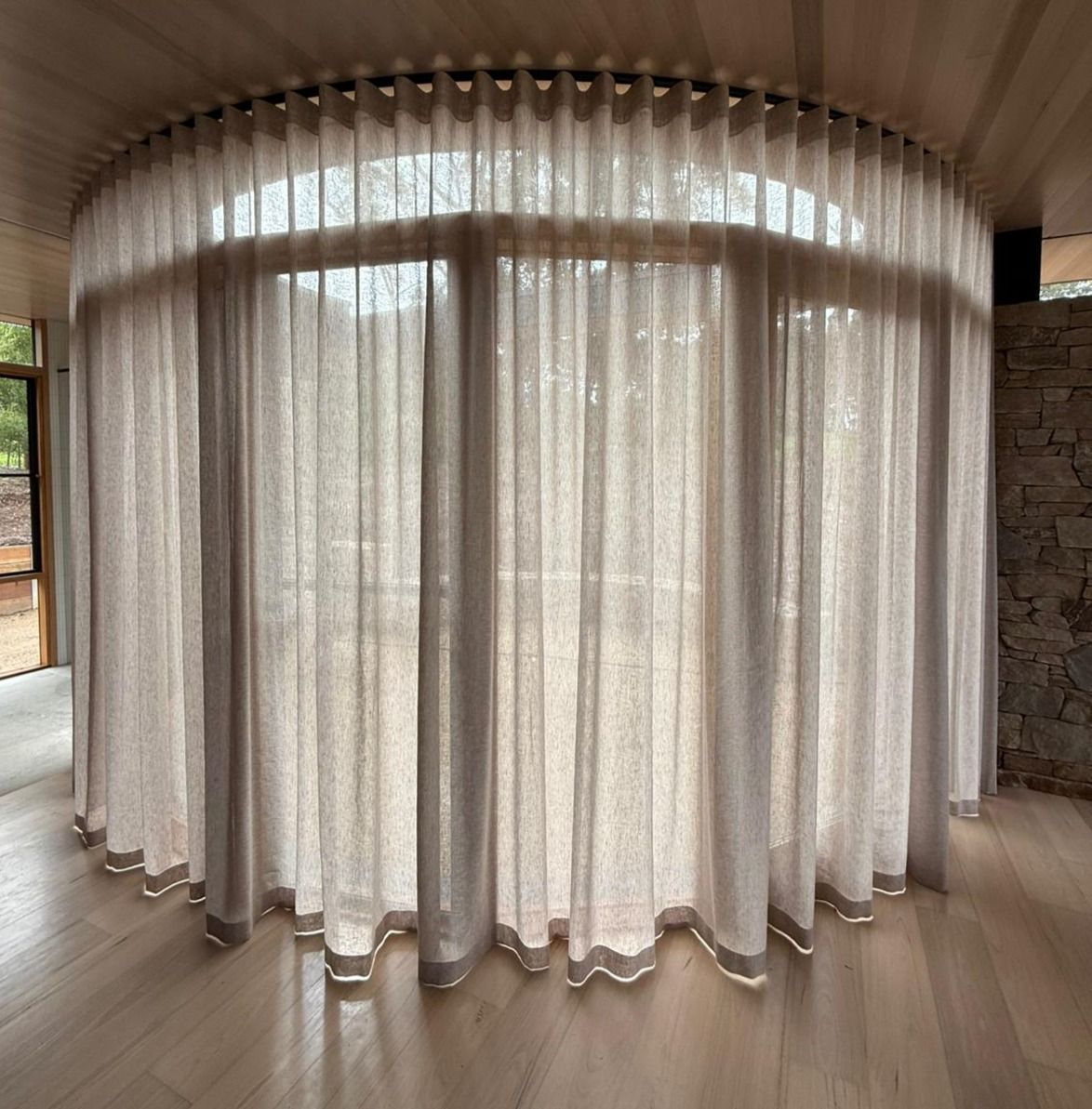 Fabric samples and curtains displayed in a store, showcasing various colors and textures.