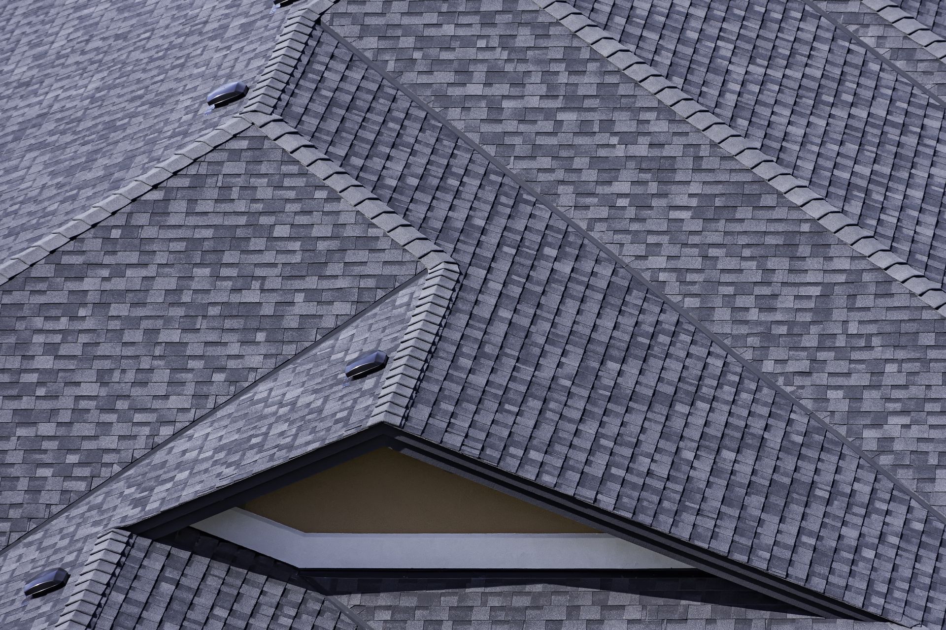 Gray shingled roof with a small dormer window and triangular gables