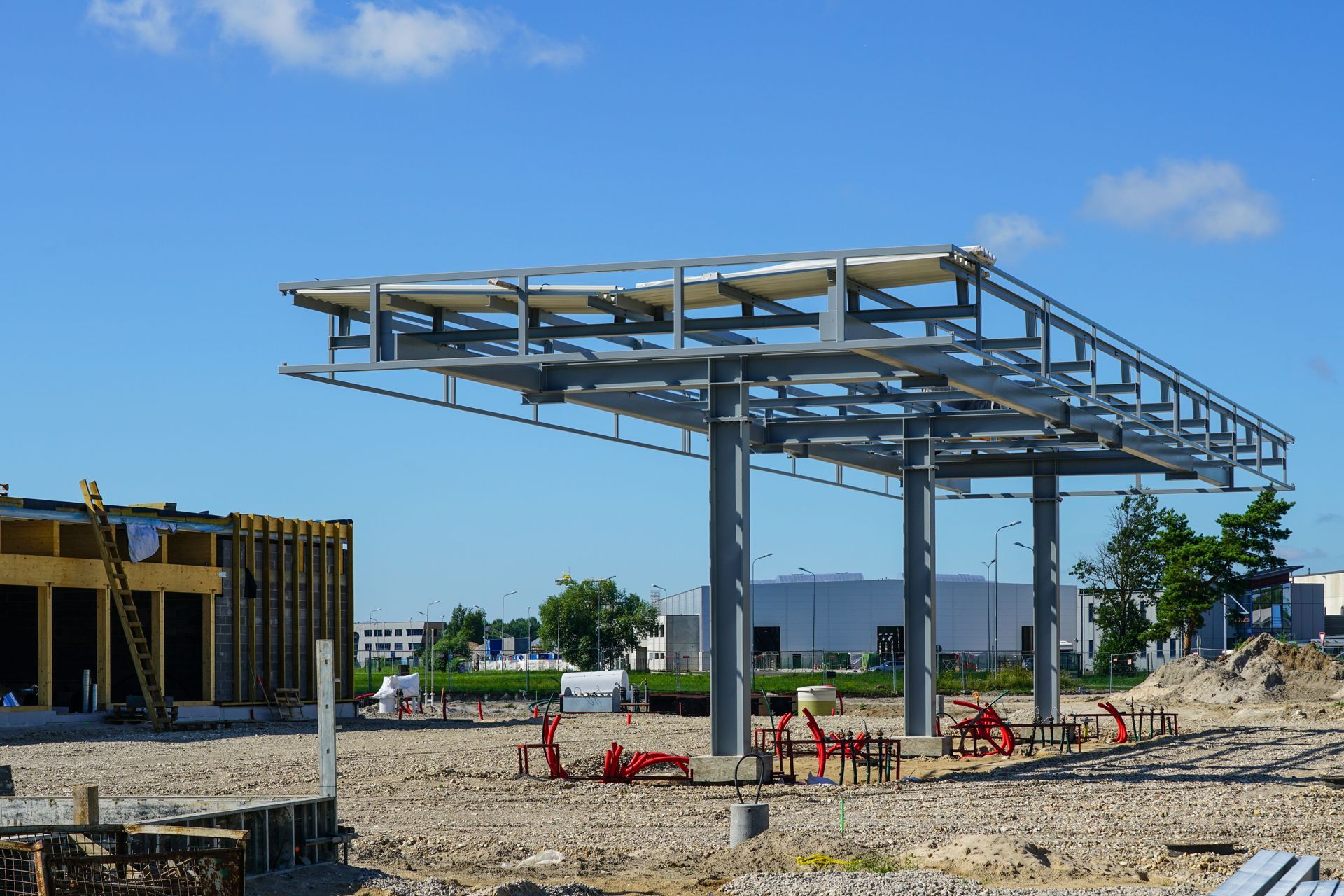 Construction site with steel frame canopy on columns under a blue sky