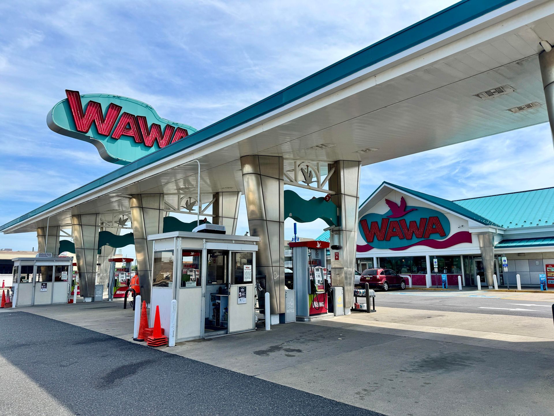 WaWa gas station canopy with pumps and convenience store entrance on a sunny day