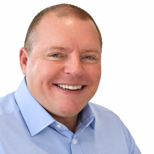 Smiling man in a light blue button-down shirt against a white background