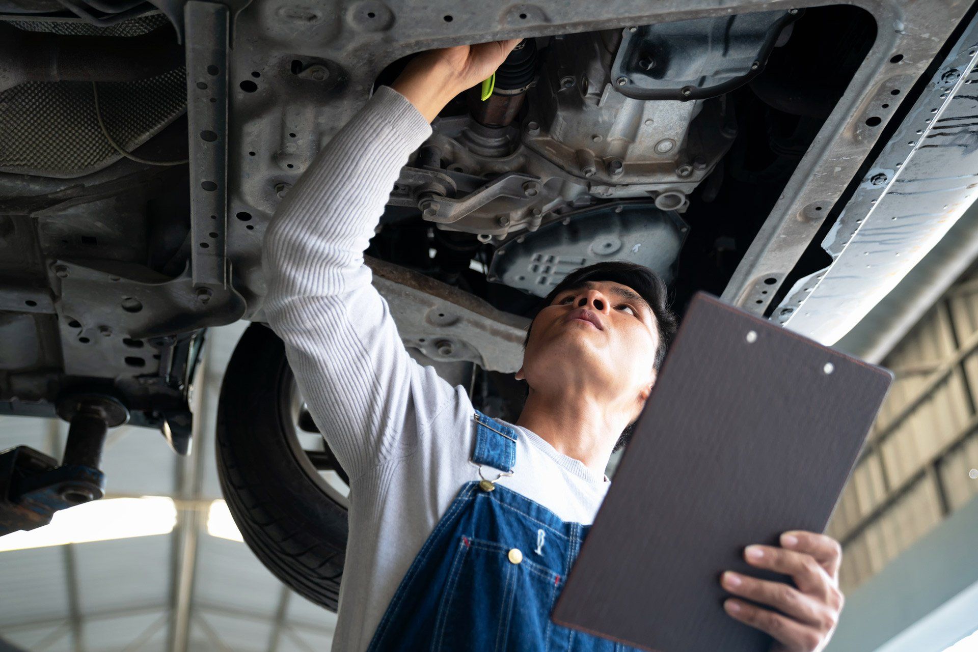 A man checking the under chassis | Sydney, NSW | Autocure Mobile Mechanics A man checking the under chassis | Sydney, NSW | Autocure Mobile Mechanics