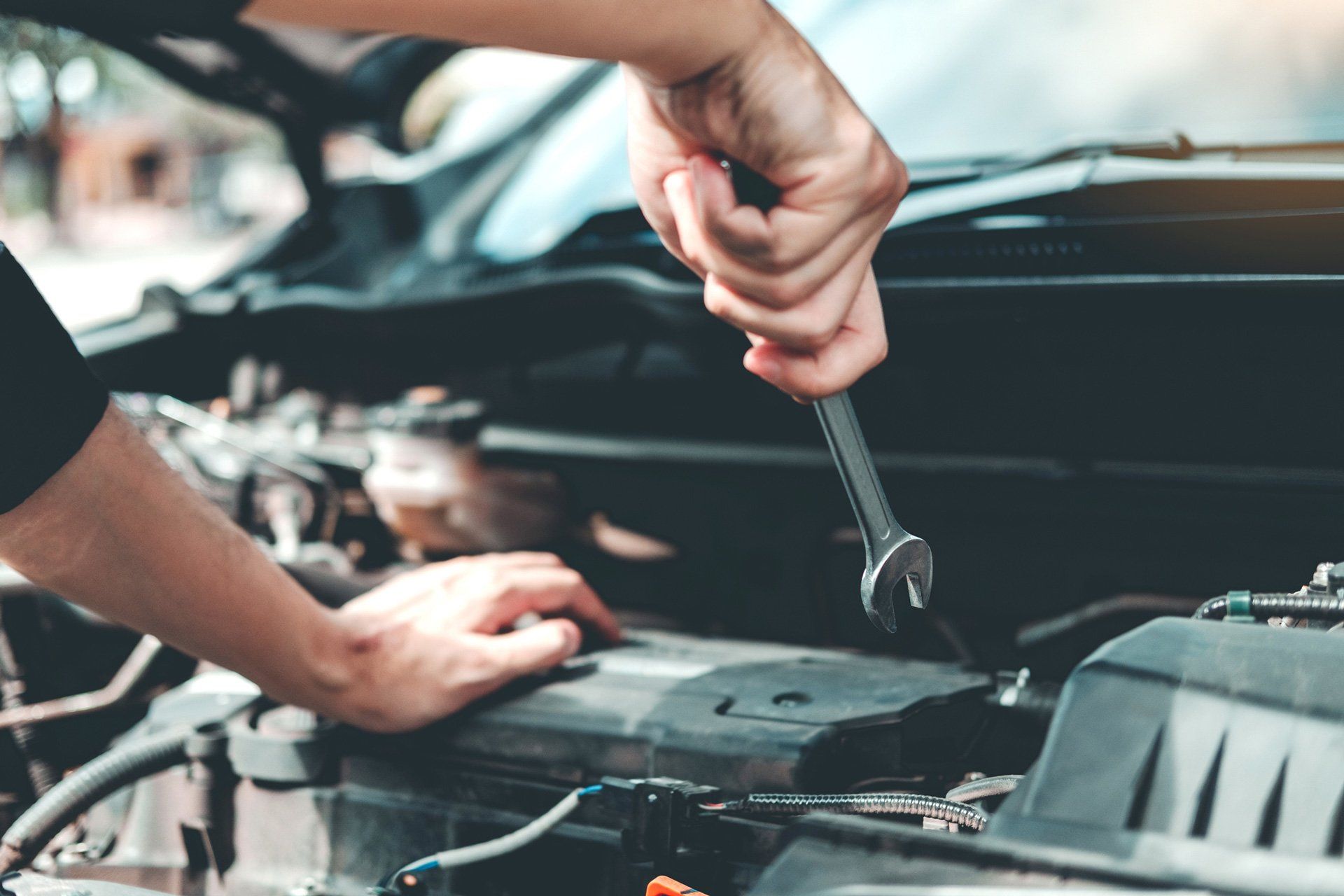 A mechanic and an open wrench on their hand doing some repair | Sydney, NSW | Autocure Mobile Mechanics