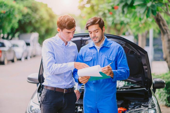 Two people looking at the paper records | Sydney, NSW | Autocure Mobile Mechanics Two people looking at the paper records | Sydney, NSW | Autocure Mobile Mechanics