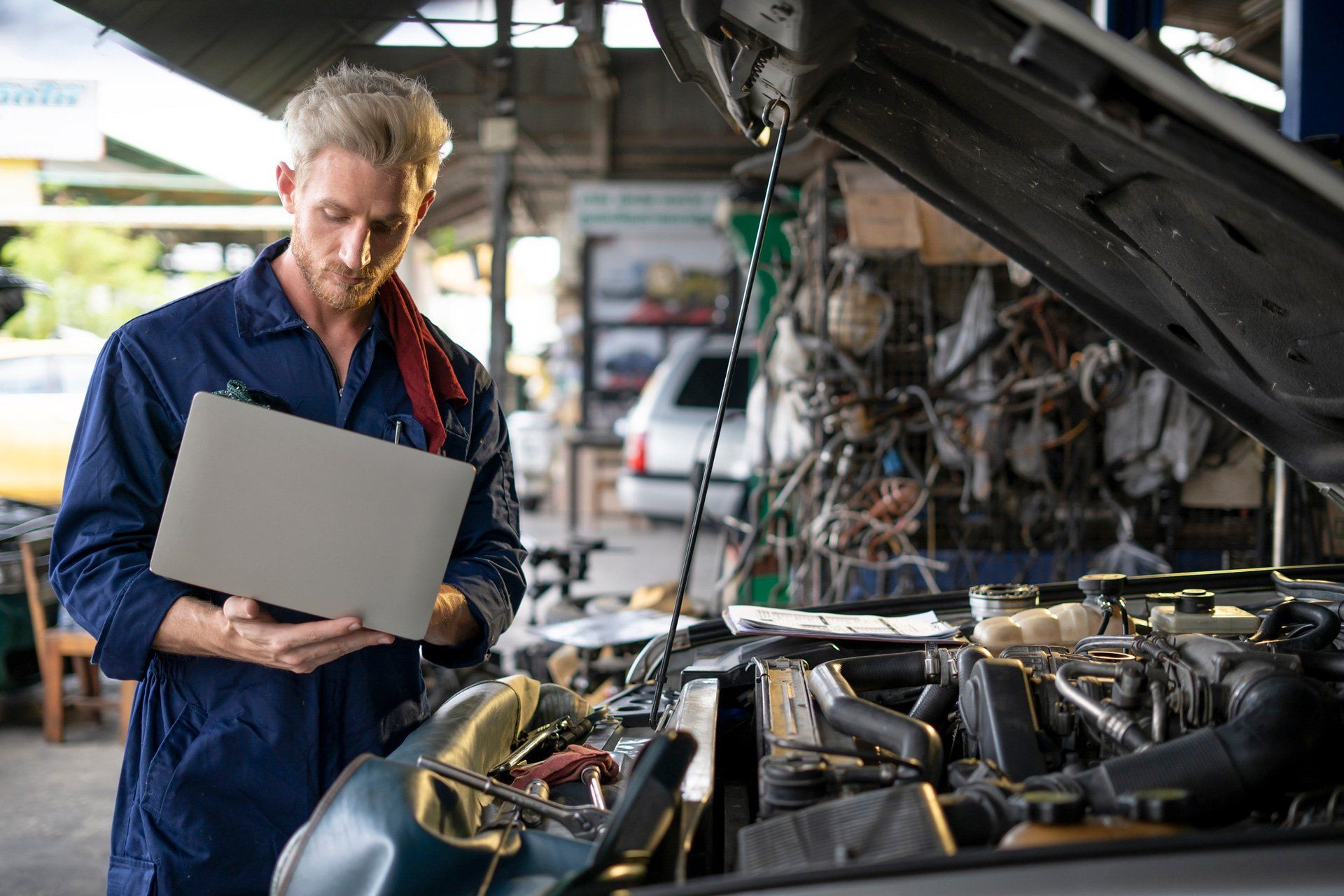 A mechanic looking at their laptop | Sydney, NSW | Autocure Mobile Mechanics A mechanic looking at their laptop | Sydney, NSW | Autocure Mobile Mechanics