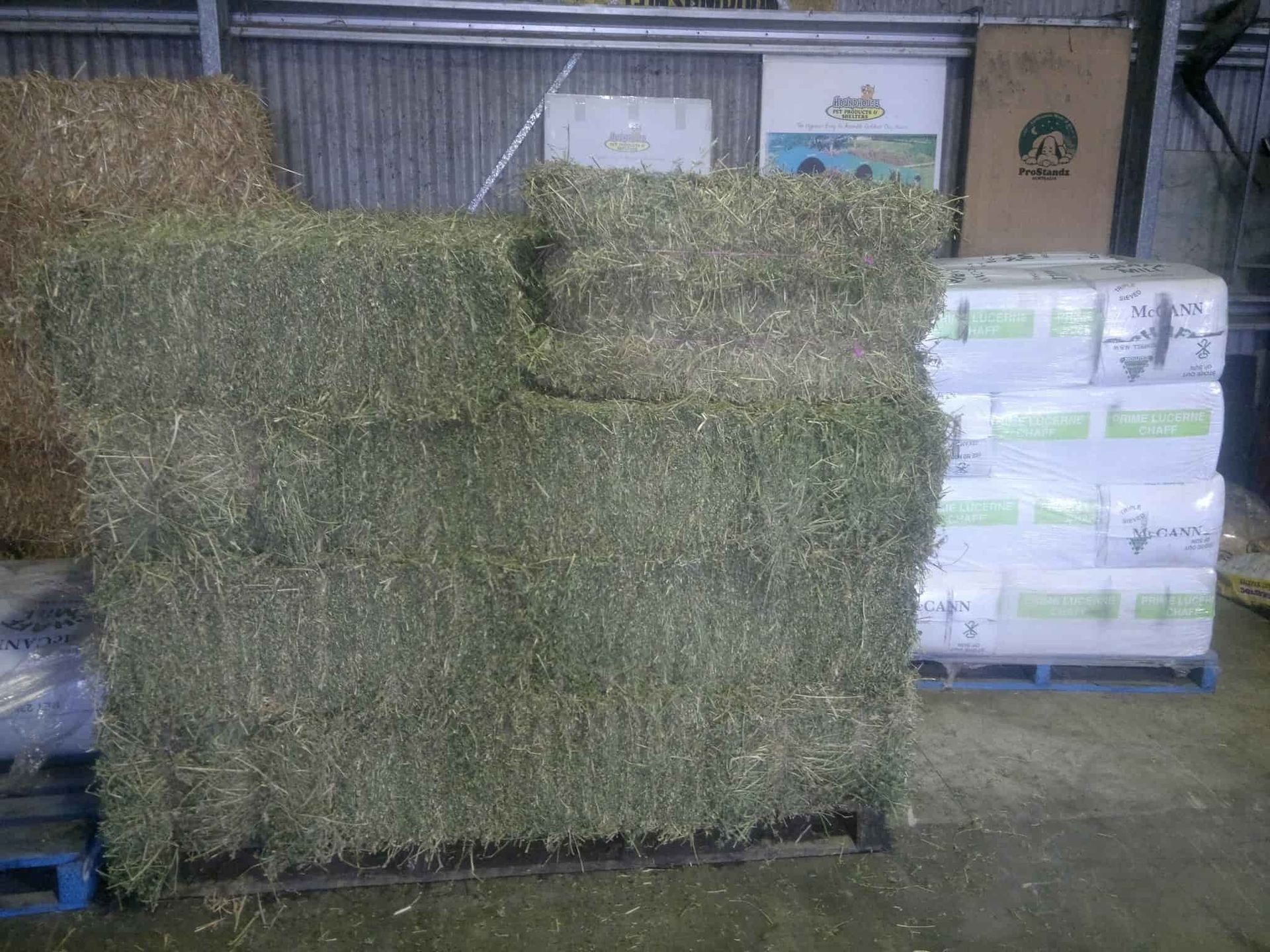 A Pile Of Hay Is Sitting On Top Of A Pallet In A Warehouse — Cooroy Produce In Cooroy, QLD