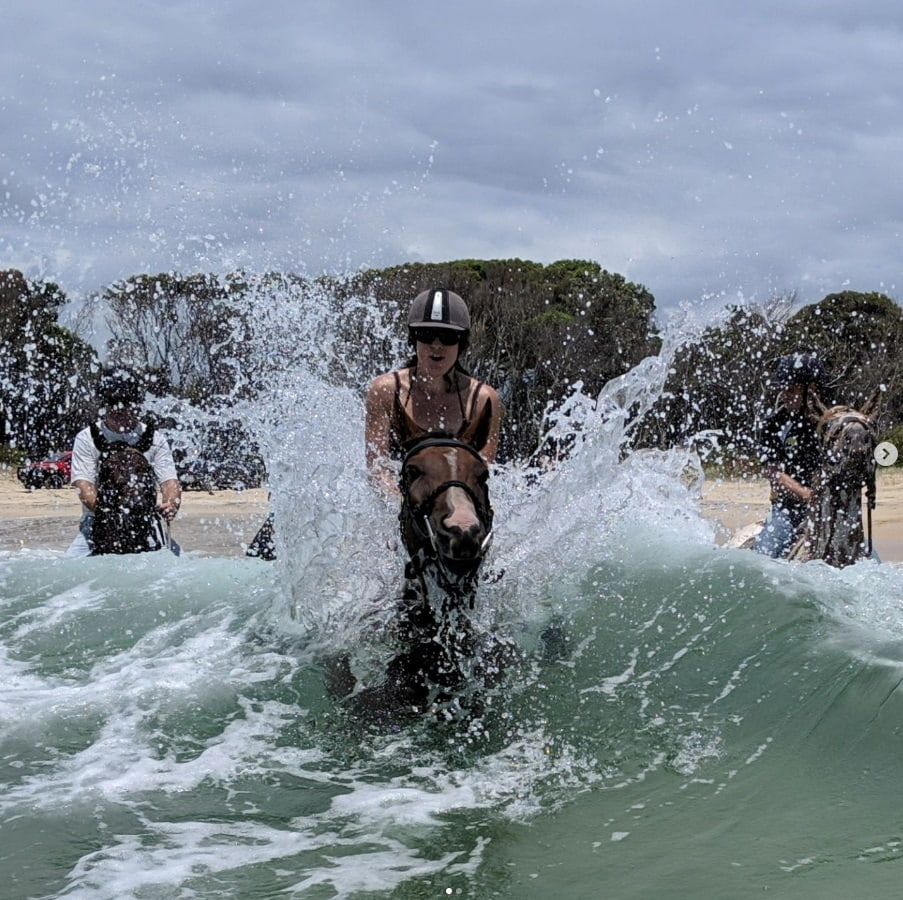 A Woman Is Riding A Horse In The Ocean — Cooroy Produce In Cooroy, QLD