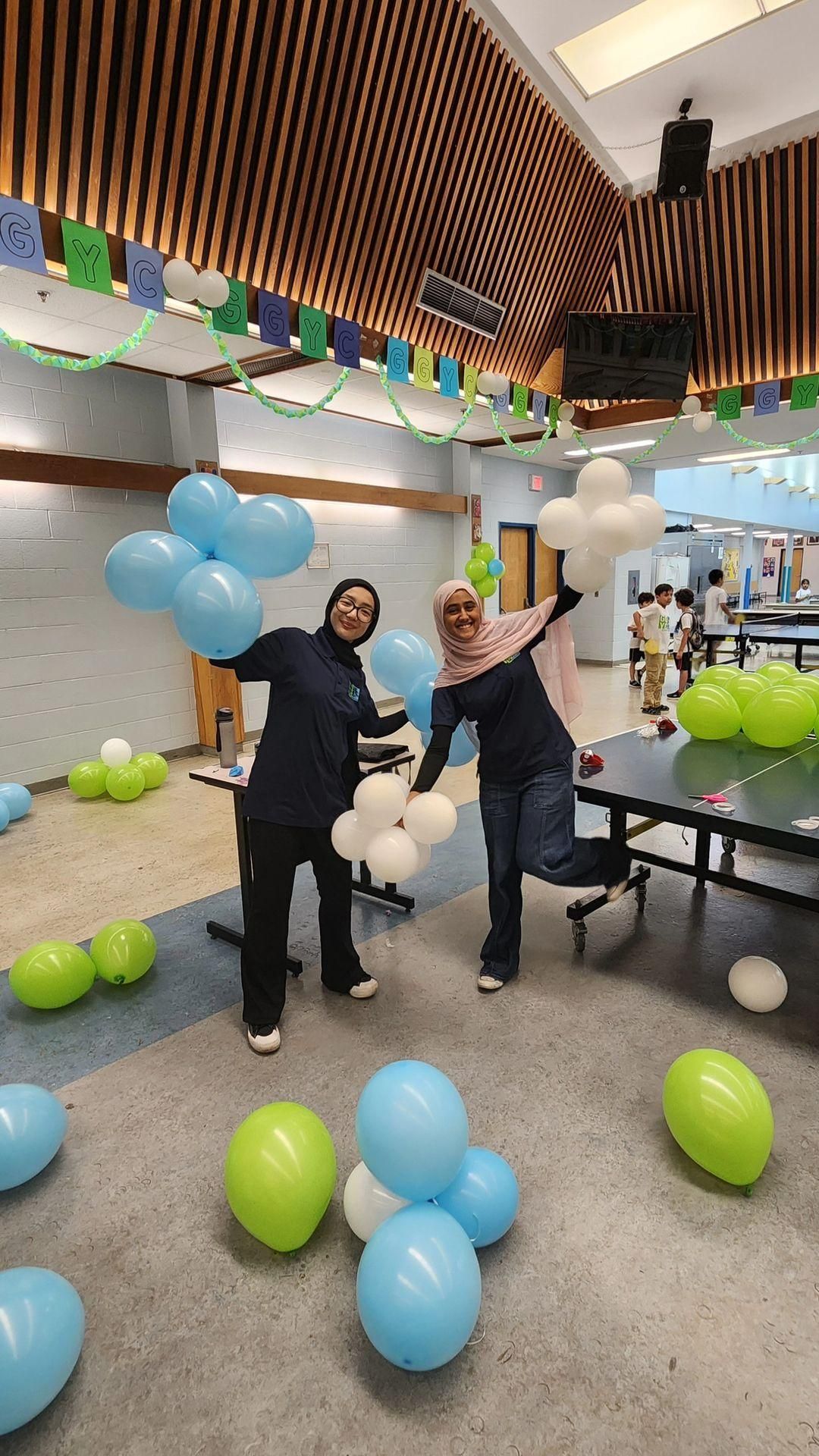 Two women are standing next to each other in a room filled with balloons.