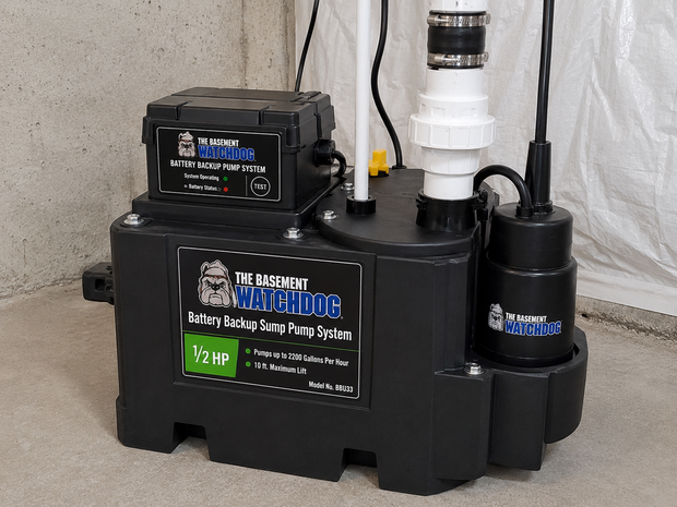 Black utility pump with hoses and labels on a concrete floor against a wall.