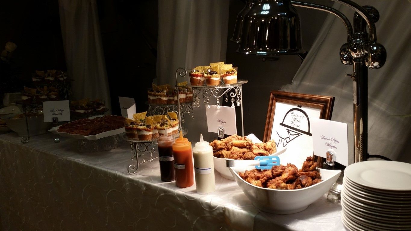 A buffet table with a variety of food and sauces on it.