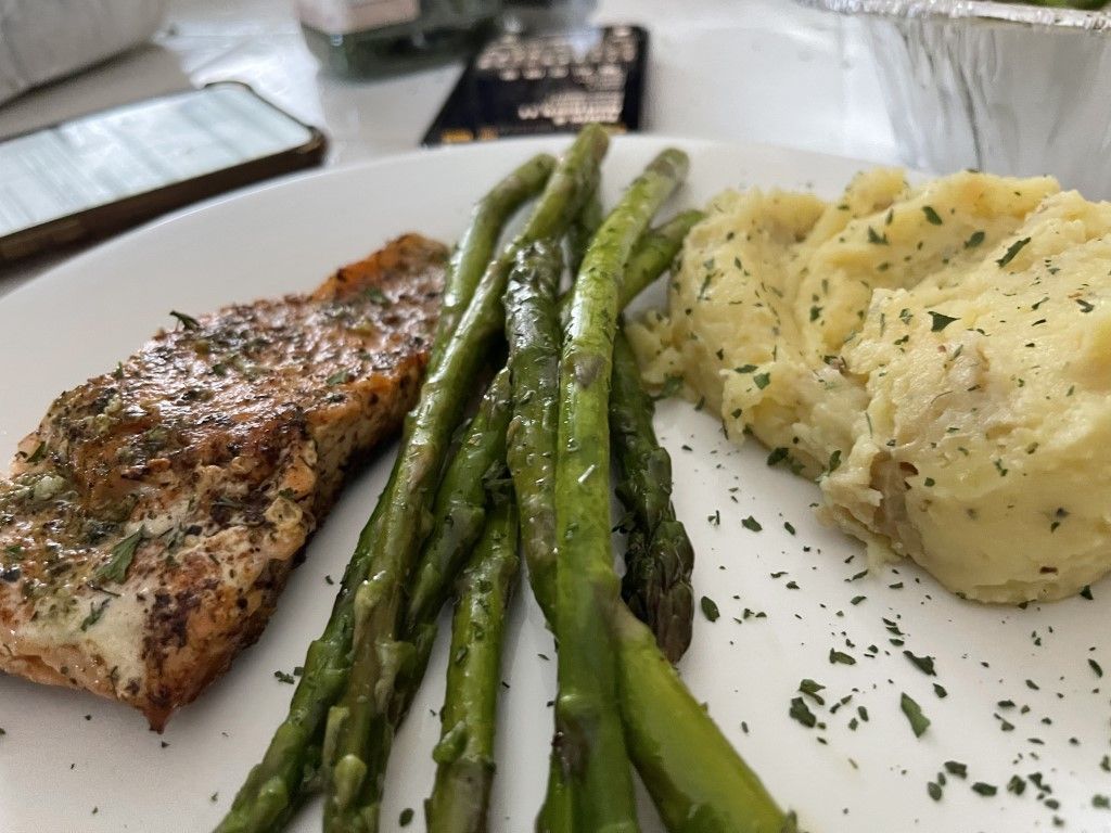 A plate of food with mashed potatoes and asparagus on a table.
