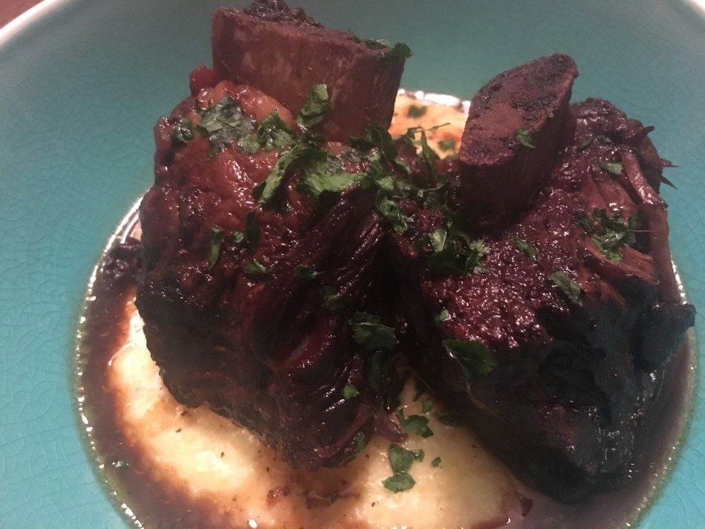 A blue bowl filled with meat and mashed potatoes