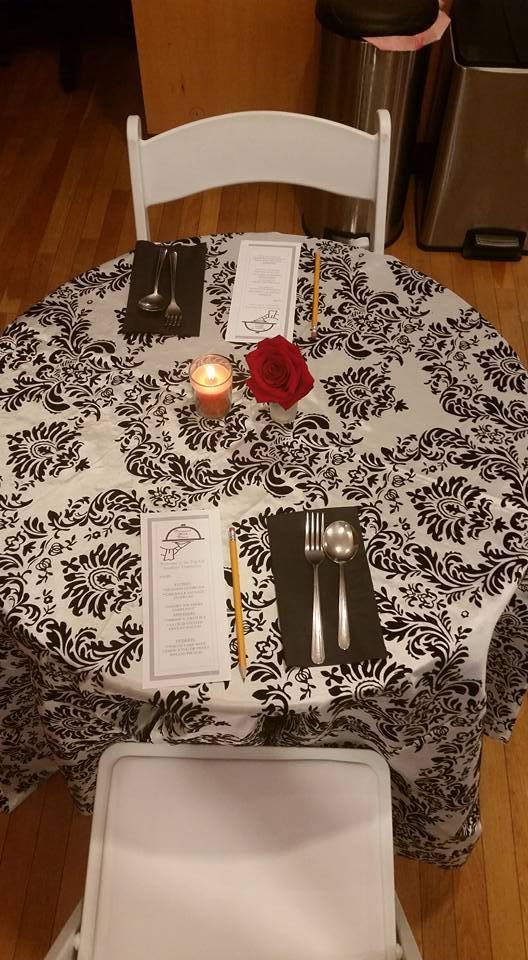 A table with a black and white tablecloth and utensils on it.