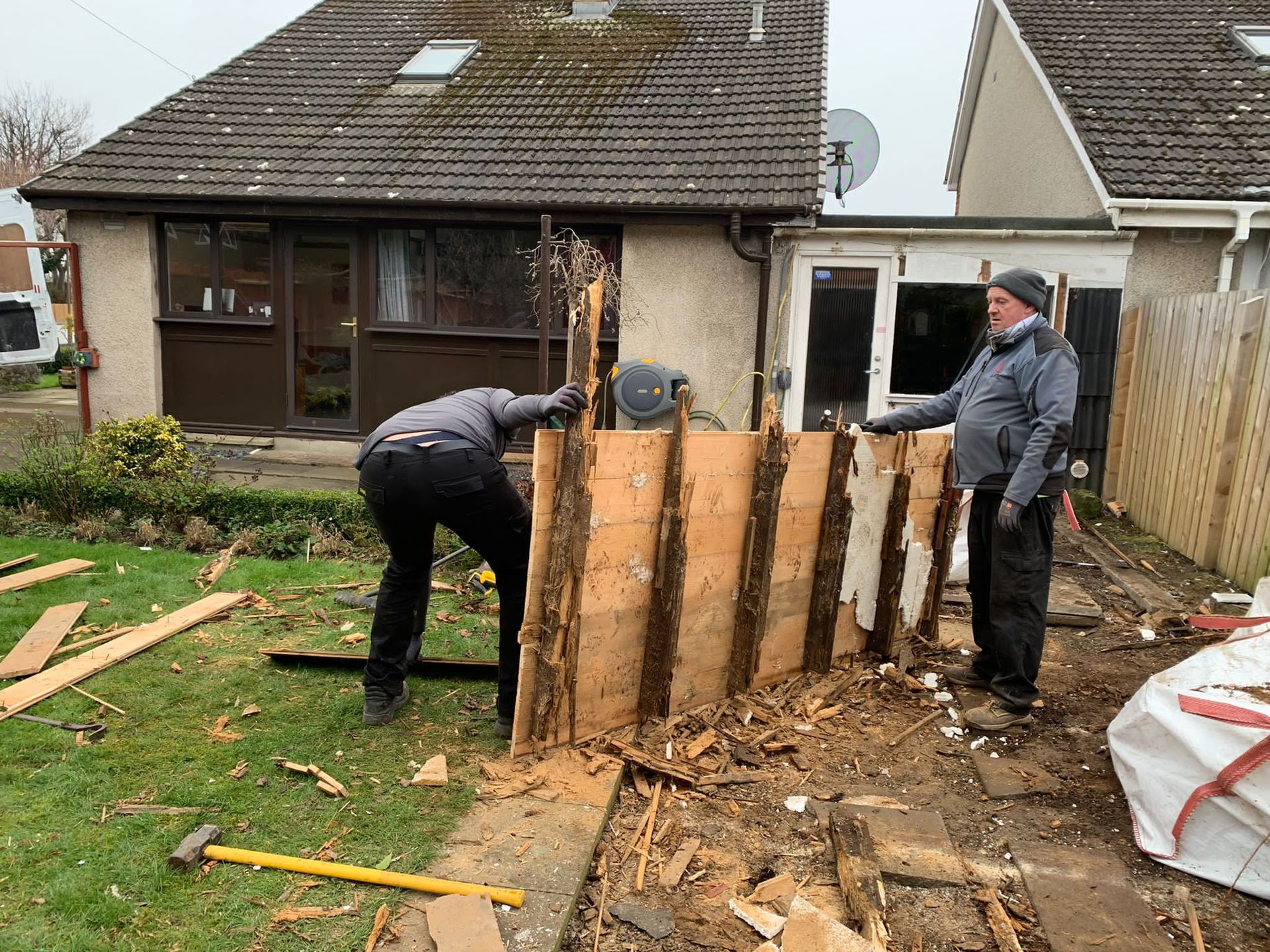 experts dismantling an old garden shed