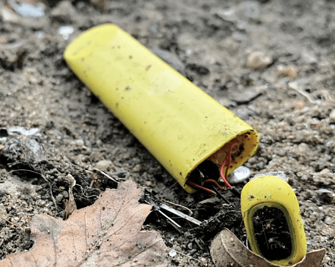 Discarded disposable vapes littering a street curb, highlighting the environmental impact of vapes.